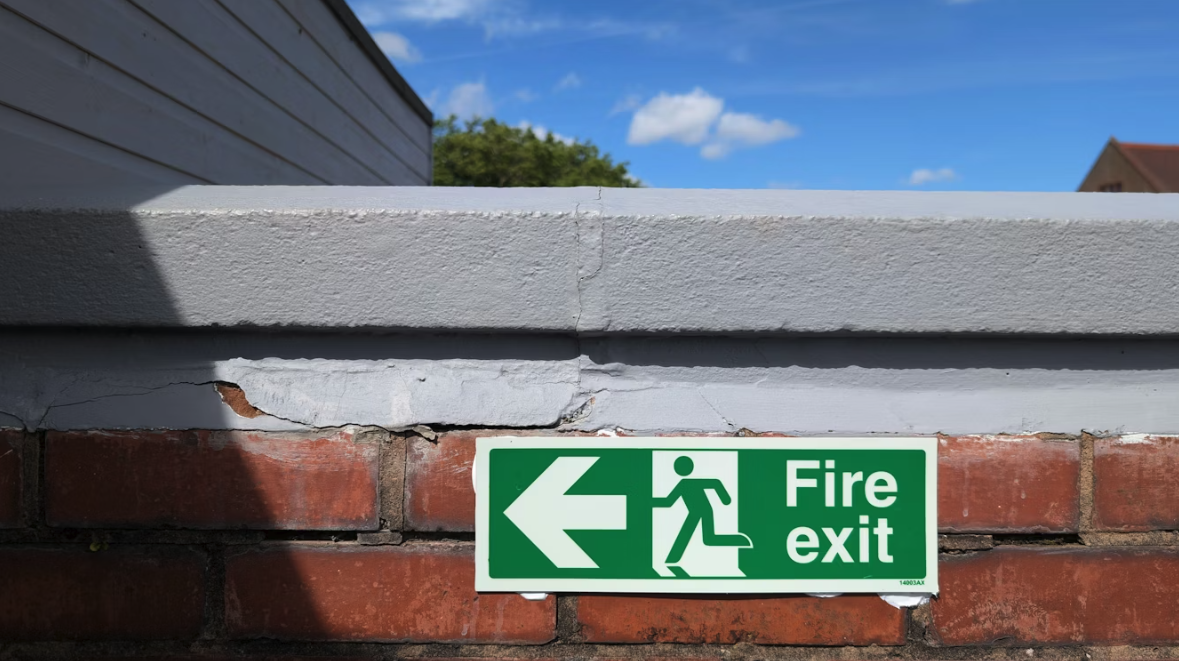 fire risk assessment signage for a fire exit on an outdoor wall